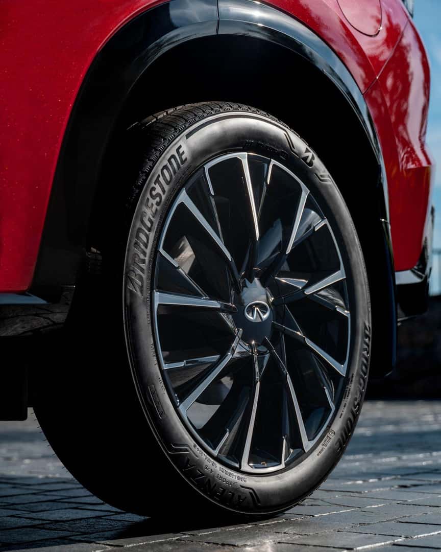 Close-up of a 2027 INFINITI QX65 alloy wheel with Bridgestone tire and black wheel-arch trim.