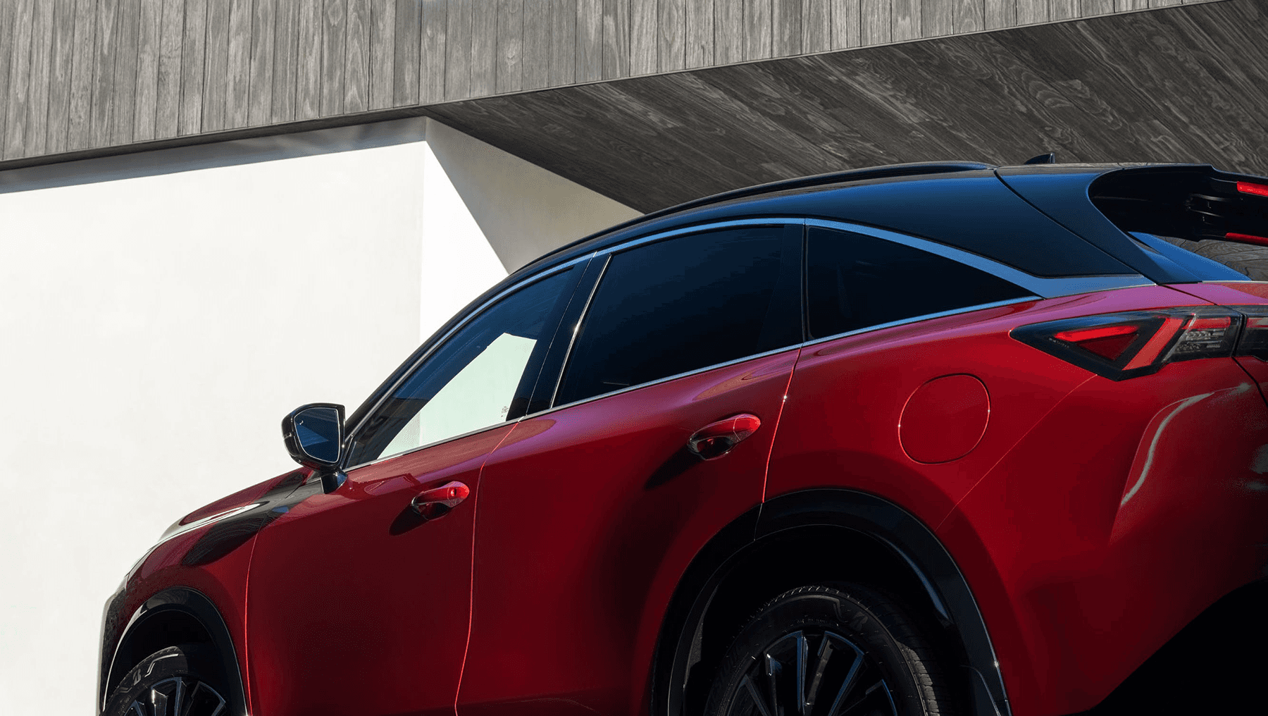 Side rear detail of the 2027 INFINITI QX65 showing the sloping roofline, rear door, fuel door, and black roof contrast.