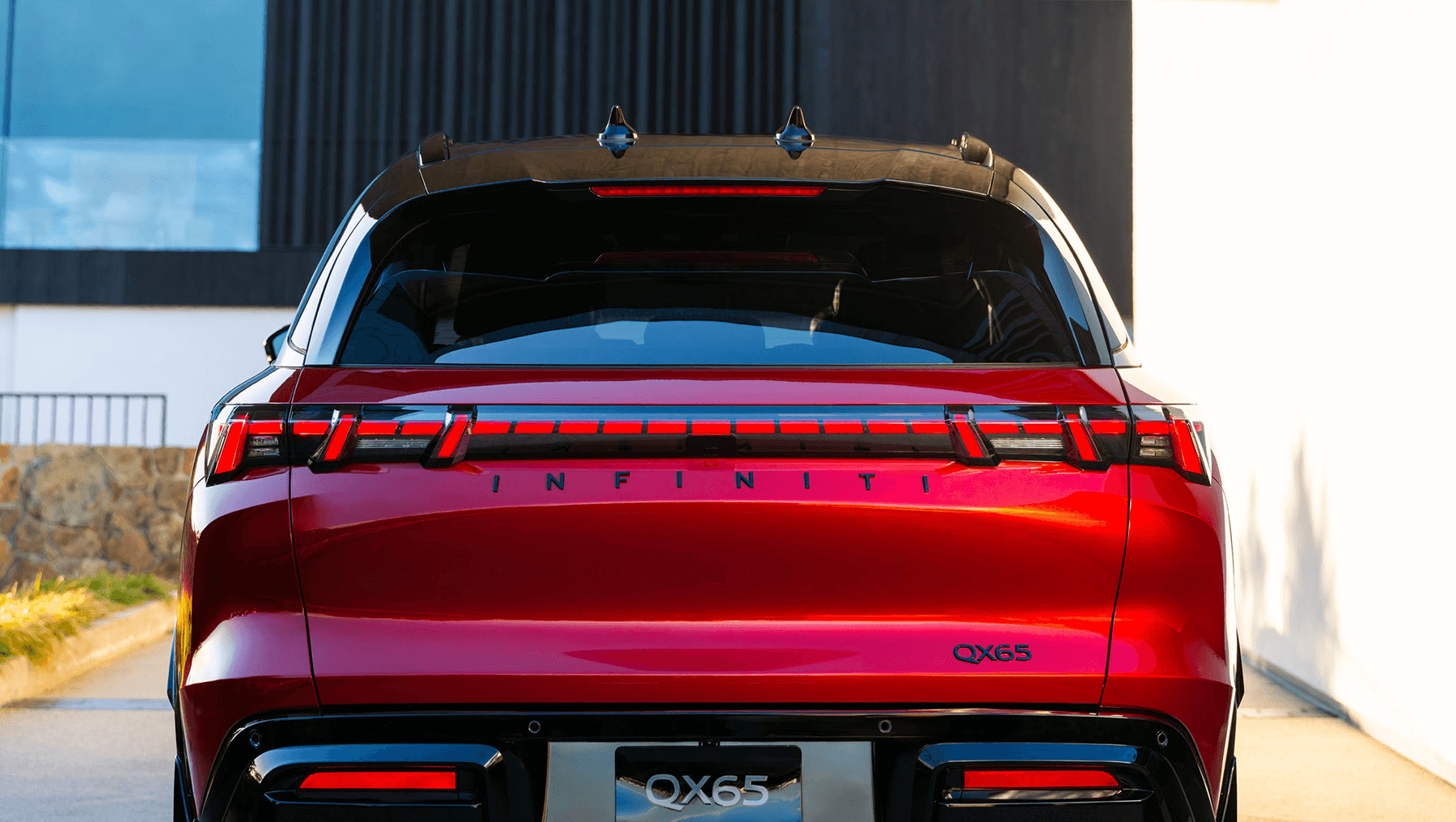 Rear view of the 2027 INFINITI QX65 with full-width taillights, INFINITI lettering, and QX65 badge.