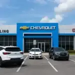 Dealer Orlando Chevrolet GMC showroom exterior with blue and white facade, Chevrolet and GMC logos, and cars parked in front of the dealership.