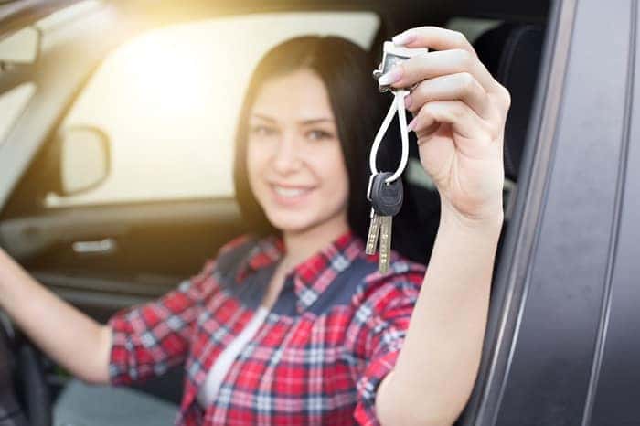 Woman shows the keys of her used car.