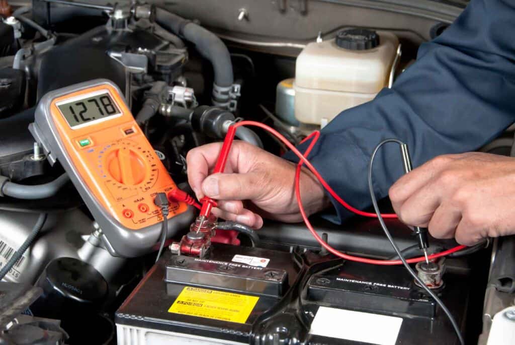 Mechanic inspecting car battery