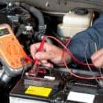 Mechanic inspecting car battery