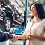 Car service center scene. The mechanic handshakes with the client