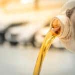 Pouring engine oil into the engine room., Gold oil during car oi
