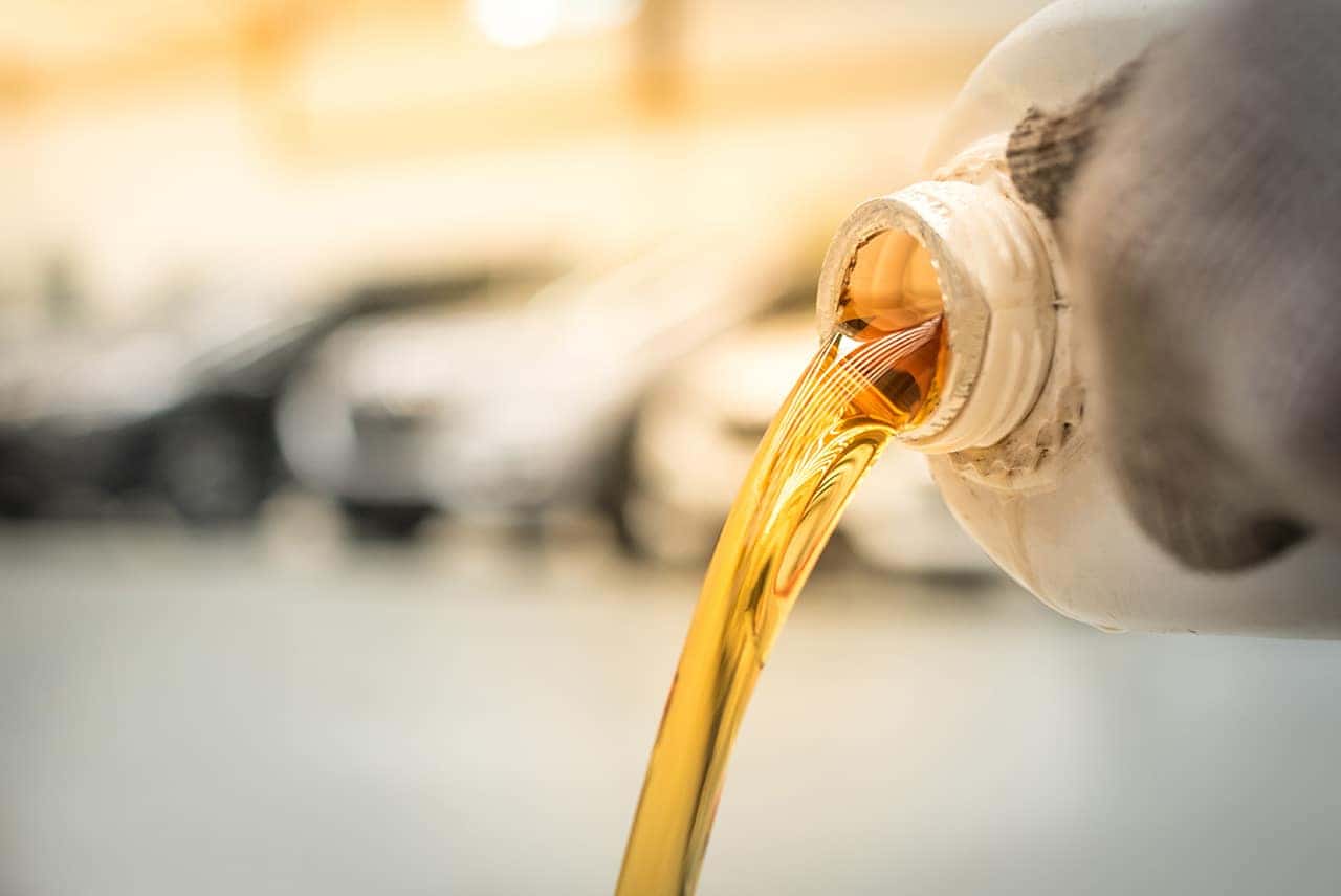 Pouring engine oil into the engine room., Gold oil during car oi