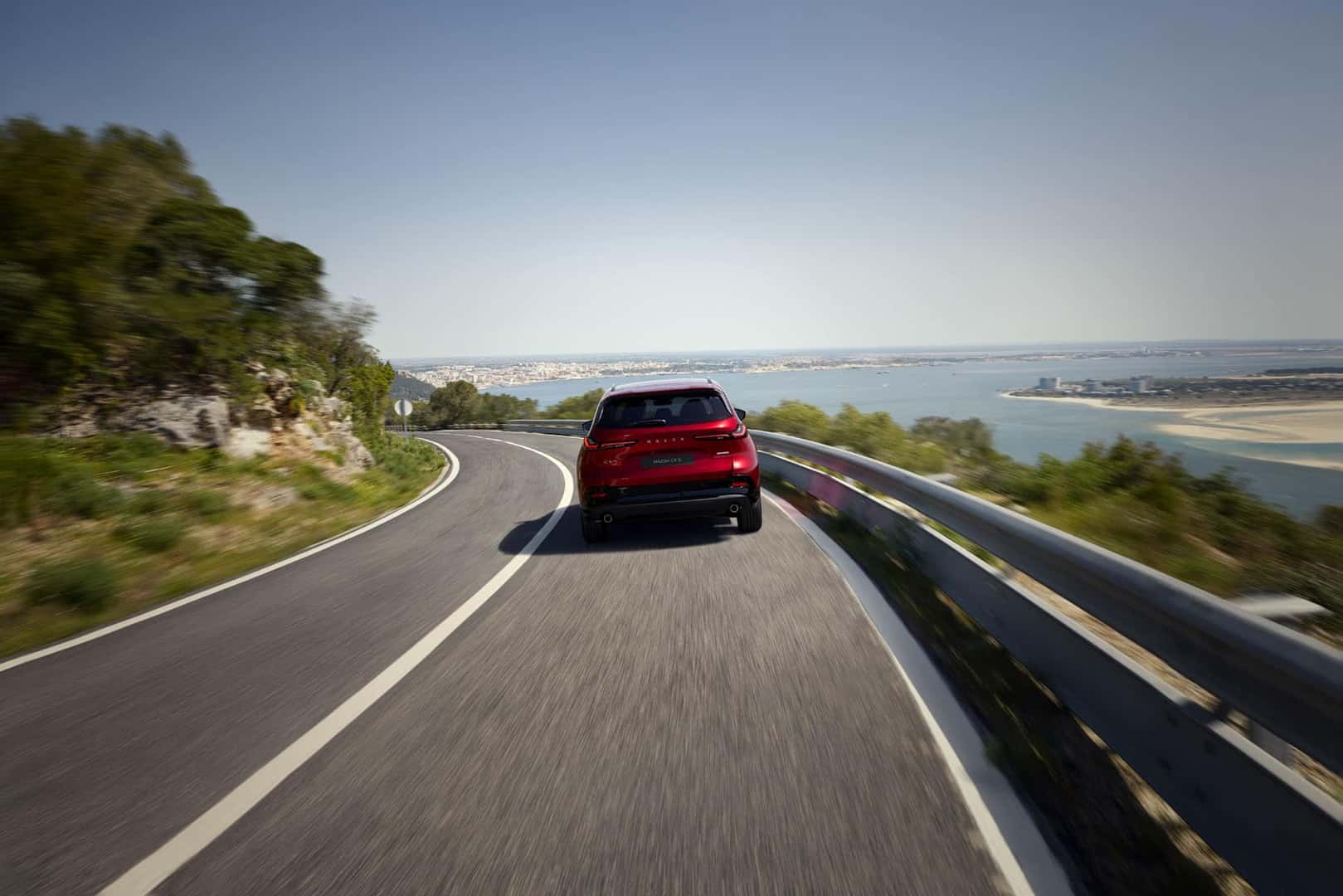 2026 Mazda CX-5 driving down a highway showcasing its i-Activsense advanced driver assistance and safety suite features