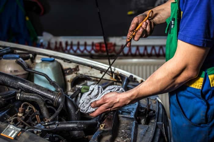 oil change technician with dipstick