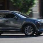 dark colored 2019 mazda cx-9 driving on city street