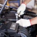 close up of mechanic working on car engine