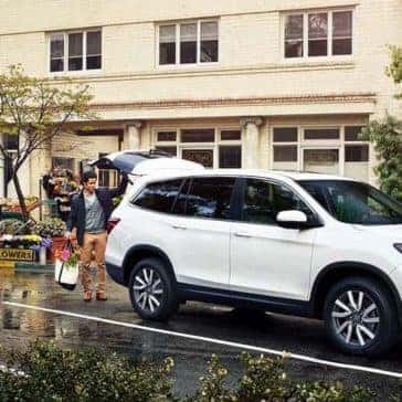 Man loading groceries into cargo area of 2019 Honda Pilot
