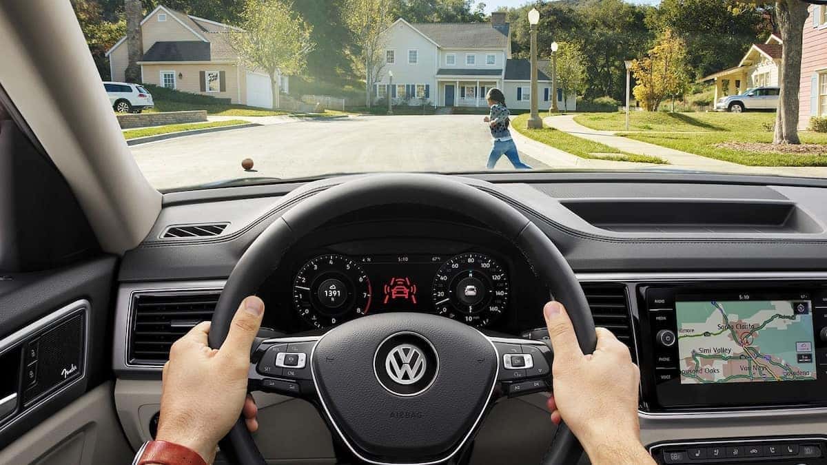 A child darts in front of a driver to chase after her ball. The front assist feature of the Atlas helps to save the child from harm.