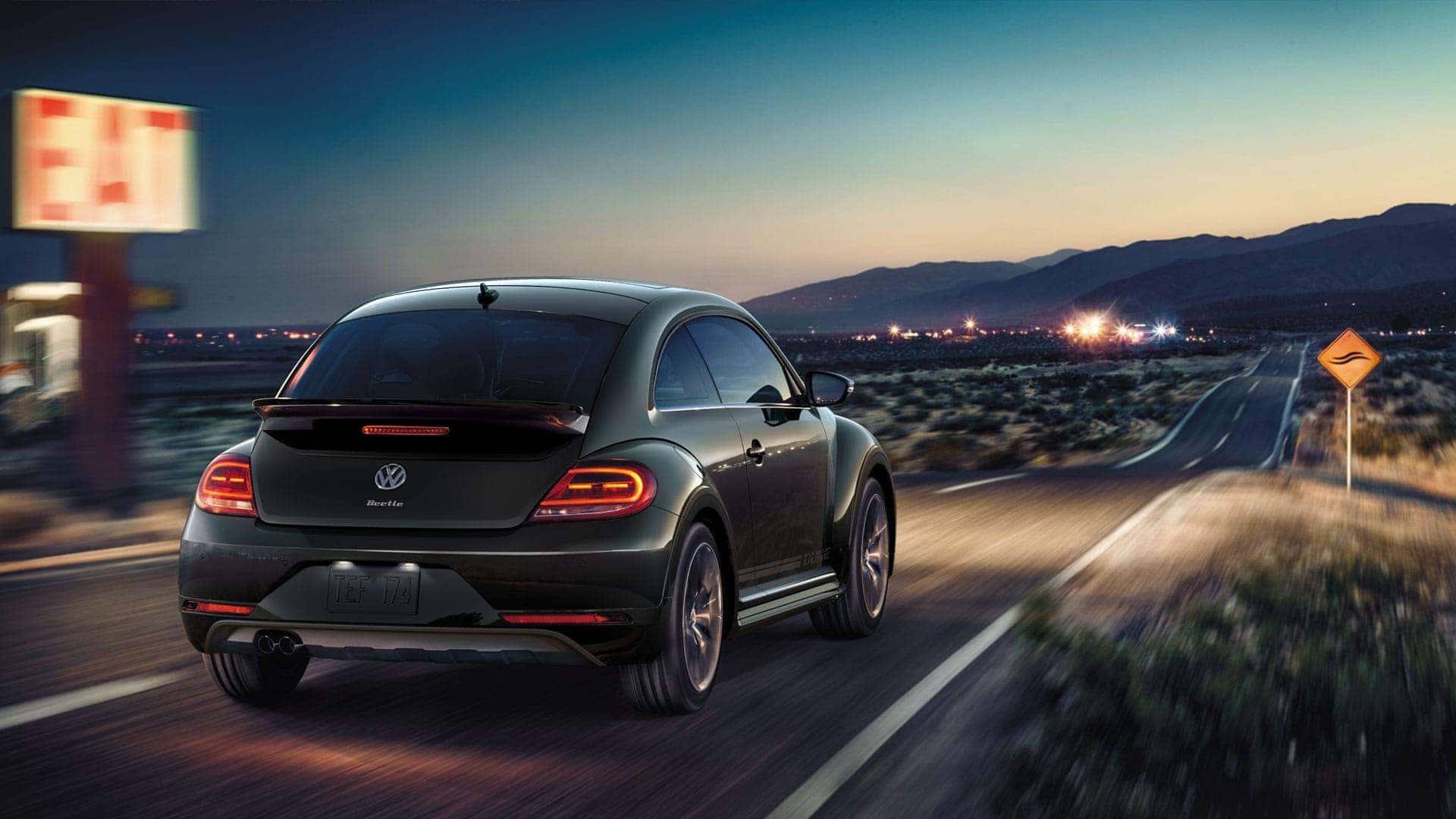 2019 VW Beetle Dune driving down a desert road at night