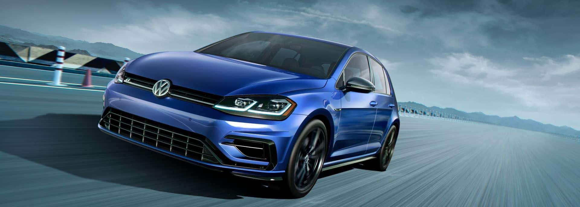 Dynamic photo of a blue 2019 VW Golf R on a race track
