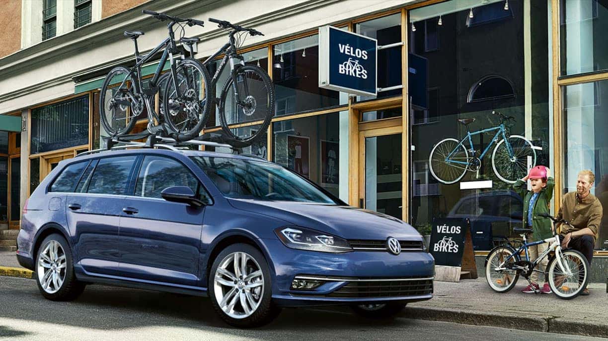 Blue 2019 VW Golf SportWagen with bikes on a roof rack