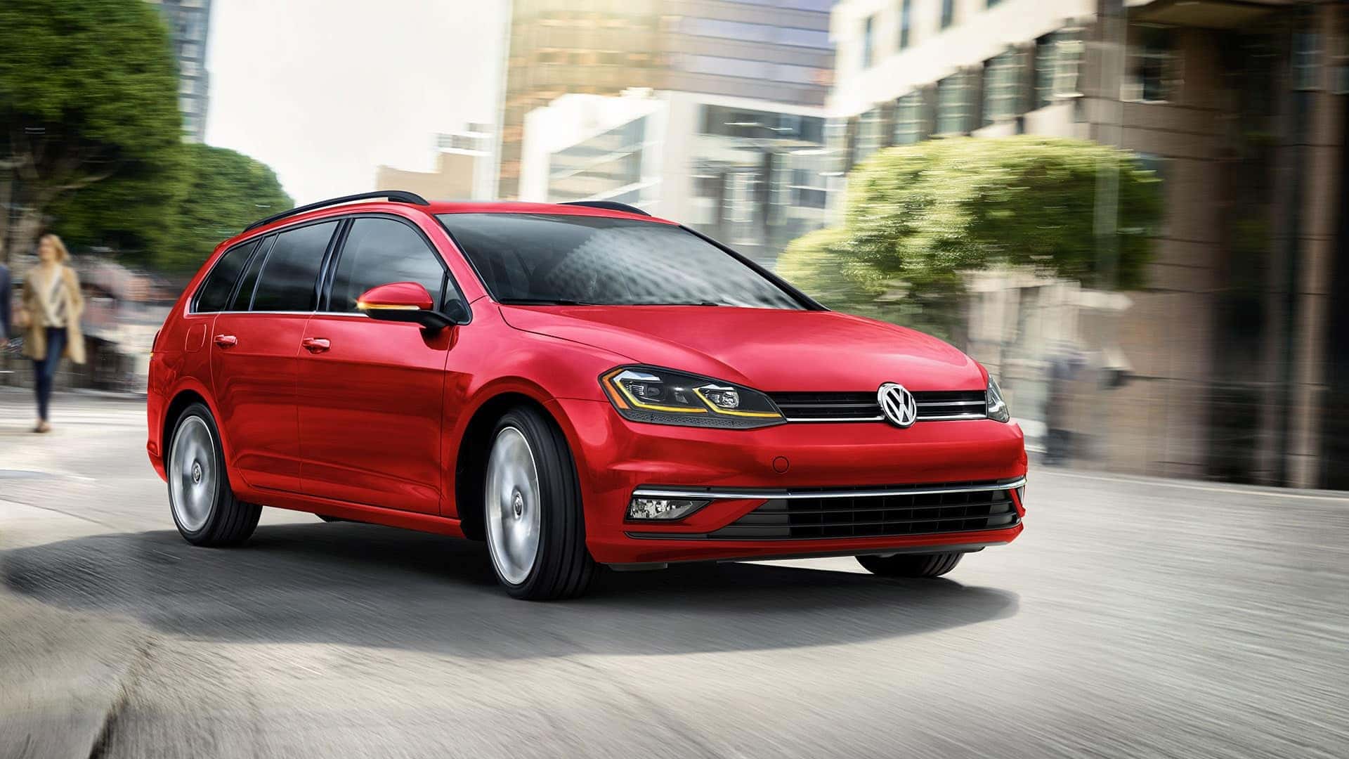 Red 2019 VW Golf SportWagen driving through a city
