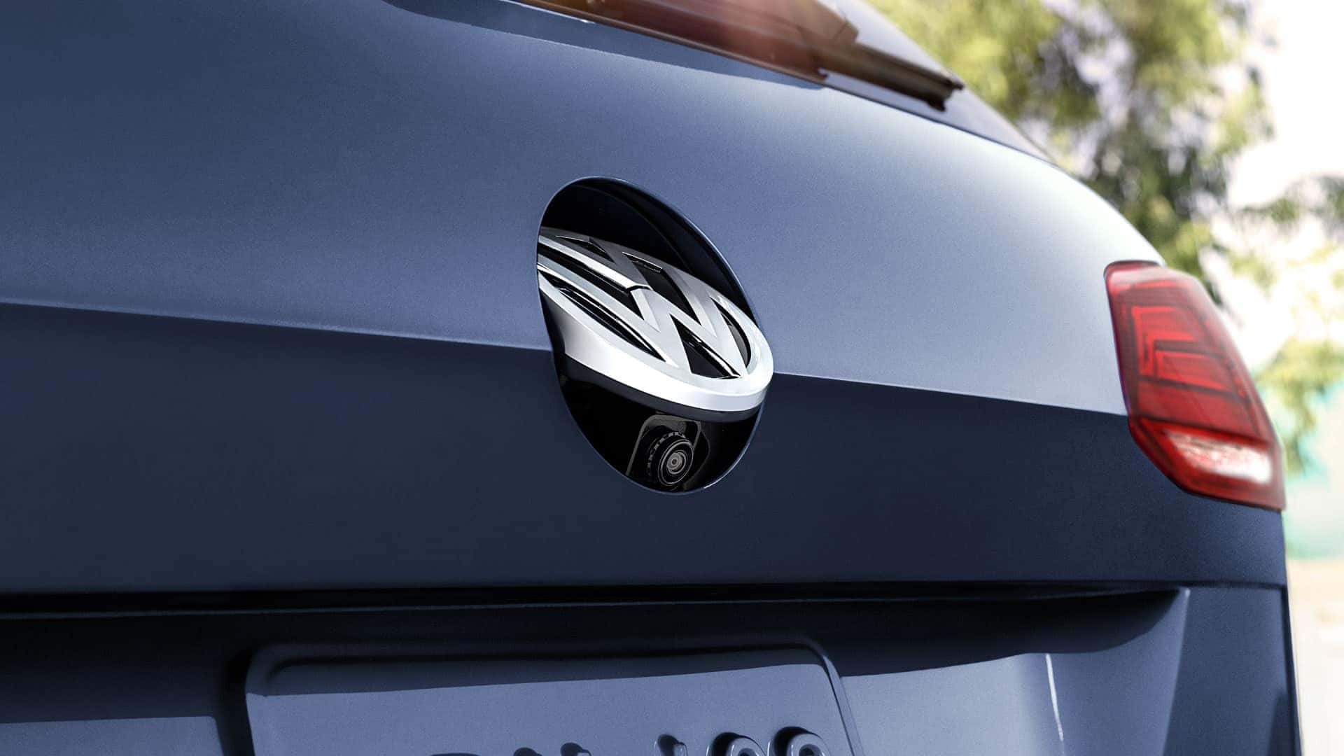 VW SportWagen rear-view camera peeking out from beneath the VW logo