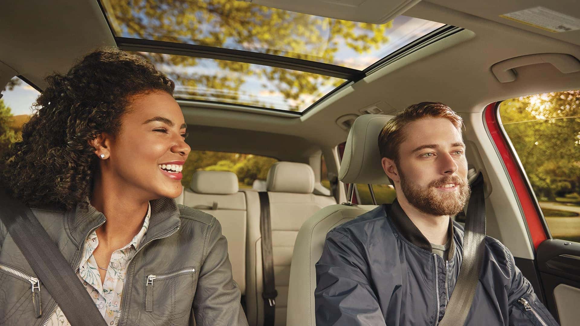 A couple in a Tiguan with a panoramic sunroof.