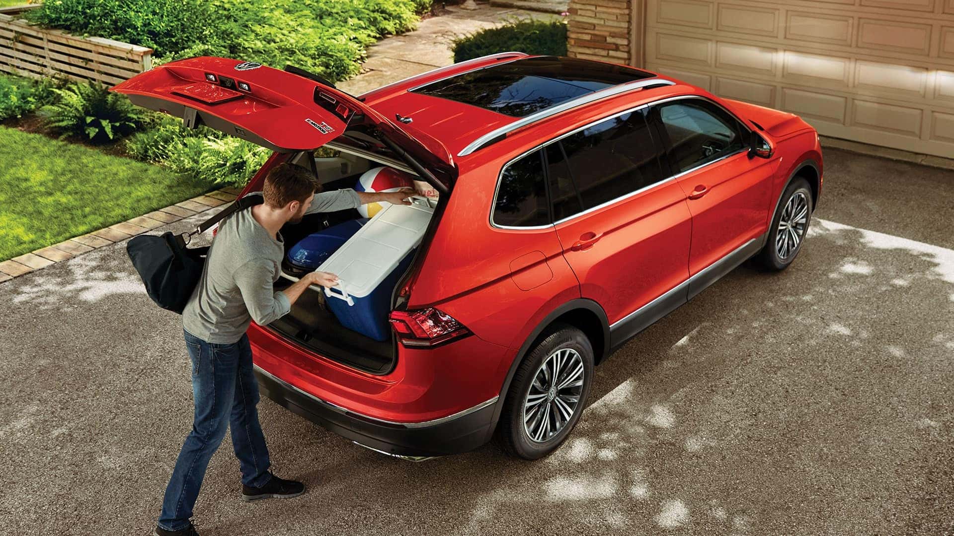 Man takes advantage of the spacious interior of the Tiguan to pack everything required for a beach barbecue.